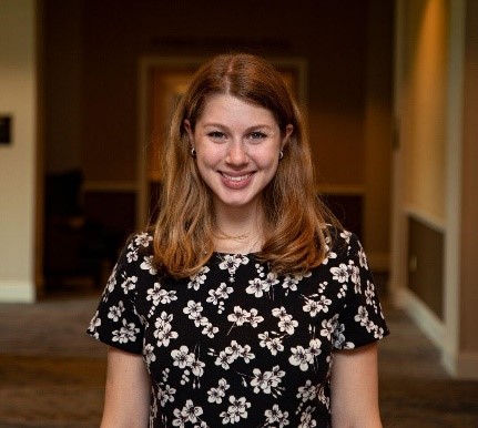 Head shot of Jennifer Wolff smiling with blonde hair and a flower shirt