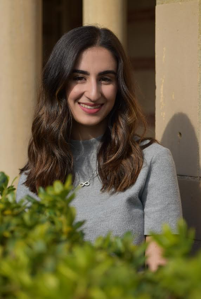 Woman with long brown hair, wearing a gray shirt